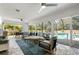 Enclosed sunroom features a comfortable seating area, views of the pool, and ample natural light at 5750 Carriage Dr, Sarasota, FL 34243