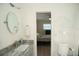Bright bathroom with a gray vanity, oval mirror, and access to the bedroom at 603 Saint Andrews Dr, Sarasota, FL 34243
