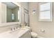 Well-lit bathroom featuring gray cabinets, quartz countertop, and a framed mirror at 6094 Amberly Dr, Bradenton, FL 34208