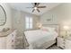 Bright bedroom with ceiling fan, shuttered window, and farmhouse-style furnishings at 6094 Amberly Dr, Bradenton, FL 34208