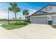 Wide concrete driveway leads to the two-car garage of this townhome with light gray exterior at 6094 Amberly Dr, Bradenton, FL 34208