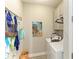 Practical laundry room with washer, dryer, storage cabinets, and beach-themed decor at 6094 Amberly Dr, Bradenton, FL 34208