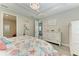 Bright main bedroom featuring a tray ceiling, a chandelier, and views to the bathroom at 6094 Amberly Dr, Bradenton, FL 34208