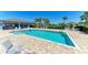 Inviting community pool area with ample lounge chairs, palm trees, and a covered patio, ideal for summer fun at 6094 Amberly Dr, Bradenton, FL 34208