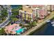 Aerial view of condo building with community pool, parking, and waterway access at 610 Riviera Dunes Way # 308, Palmetto, FL 34221