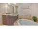 Elegant bathroom featuring granite counters, a soaking tub, and a tile backsplash at 610 Riviera Dunes Way # 308, Palmetto, FL 34221