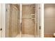 Tiled shower with glass door, shower head, and a built-in soap and shampoo shelf at 610 Riviera Dunes Way # 308, Palmetto, FL 34221