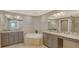 Luxurious bathroom with granite counters, double sinks, and a soaking tub at 610 Riviera Dunes Way # 308, Palmetto, FL 34221