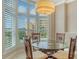 Dining area features a glass table, rattan chairs, and shuttered windows overlooking tropical views at 610 Riviera Dunes Way # 308, Palmetto, FL 34221