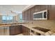 Bright kitchen with granite countertops, stainless appliances, and views of the living area at 610 Riviera Dunes Way # 308, Palmetto, FL 34221