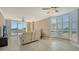 Spacious living room with tiled floors, ceiling fans, shuttered windows, and balcony access at 610 Riviera Dunes Way # 308, Palmetto, FL 34221