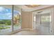 Open living room with tile floors, and a balcony overlooking the neighboring buildings and waterway at 610 Riviera Dunes Way # 308, Palmetto, FL 34221