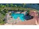 Aerial shot of community pool, lush landscaping, lounge chairs, and tropical foliage at 610 Riviera Dunes Way # 308, Palmetto, FL 34221
