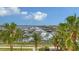 Panoramic waterfront view with palm trees and boats under a blue sky with scattered clouds at 610 Riviera Dunes Way # 308, Palmetto, FL 34221