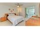 Bedroom with light carpet, ceiling fan, light wood furniture, and sliding glass door to outdoor area at 6101 34Th W St # 28E, Bradenton, FL 34210