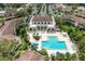 Aerial view of a community pool with seating, lush landscaping and a beautiful clubhouse at 6101 34Th W St # 28E, Bradenton, FL 34210