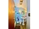 Well-lit bathroom featuring a pedestal sink, decorative mirror, and storage shelf at 6265 Viola Ln, New Port Richey, FL 34653