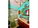 Bathroom with a sink, a toilet, a shower with a glass door, and decorated teal walls at 6265 Viola Ln, New Port Richey, FL 34653