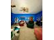 Spacious living room with a recliner chair, an armchair, and a bed with blue walls at 6265 Viola Ln, New Port Richey, FL 34653