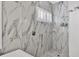 Modern shower with marble-look tile and white accents, showcasing stylish and functional design at 6470 Indigo Bunting Pl, Lakewood Ranch, FL 34202