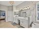 Bathroom featuring dual sinks, a modern bathtub, with elegant lighting, and a door to the bedroom at 6470 Indigo Bunting Pl, Lakewood Ranch, FL 34202