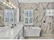 Spa-like bathroom featuring a modern bathtub with marble walls and dual sinks at 6470 Indigo Bunting Pl, Lakewood Ranch, FL 34202