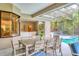 Relaxing screened-in lanai with dining set, overlooking the pool and lush backyard at 6470 Indigo Bunting Pl, Lakewood Ranch, FL 34202