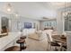 Open-concept living room featuring a modern sectional sofa, sleek lighting, and natural light at 6470 Indigo Bunting Pl, Lakewood Ranch, FL 34202