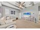 Bright living room features beamed ceilings, fan, and comfortable sectional couch at 6470 Indigo Bunting Pl, Lakewood Ranch, FL 34202