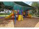 A playground with colorful slides and ladders under a green canopy at 6470 Indigo Bunting Pl, Lakewood Ranch, FL 34202