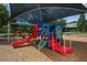 A playground with colorful slides and ladders, under a sun shade at 6470 Indigo Bunting Pl, Lakewood Ranch, FL 34202