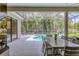 Inviting pool area with screened-in lanai, dining set, and tropical landscaping at 6470 Indigo Bunting Pl, Lakewood Ranch, FL 34202