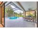 Inviting pool area with screened-in lanai, dining set, and tropical landscaping at 6470 Indigo Bunting Pl, Lakewood Ranch, FL 34202