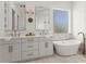 This primary bathroom features double sinks, a soaking tub, decorative mirrors and bronze fixtures at 705 89Th Nw Ct, Bradenton, FL 34209