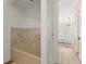 Partial view of a bathroom with a soaking tub, marble accent tiles, and natural light at 705 89Th Nw Ct, Bradenton, FL 34209