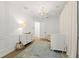 Bright Bedroom with white wainscoting, lovely rug, stylish chandelier, and white crib at 705 89Th Nw Ct, Bradenton, FL 34209
