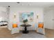 Sitting area with modern art, two chairs, a round table, and luxury vinyl flooring at 705 89Th Nw Ct, Bradenton, FL 34209