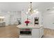 Bright, modern kitchen with white cabinetry, stainless steel appliances, marble countertops, and a stylish island with pendant lighting at 705 89Th Nw Ct, Bradenton, FL 34209