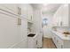Clean laundry room featuring white cabinets, modern appliances, and sleek countertops at 705 89Th Nw Ct, Bradenton, FL 34209
