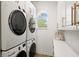 Laundry room with stacked washer and dryer, with modern white cabinetry at 705 89Th Nw Ct, Bradenton, FL 34209