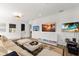 Cozy living room with sectional seating, multiple televisions, and stylish decor for a casual living space at 705 89Th Nw Ct, Bradenton, FL 34209