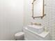 This stylish powder room includes designer wallpaper, a unique sink, and gold fixtures at 705 89Th Nw Ct, Bradenton, FL 34209