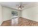 Bedroom with wood floors, ceiling fan, and sliding glass door leading to screened patio at 7810 34Th E Ct, Sarasota, FL 34243