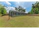 Expansive backyard featuring a screened-in patio, lush lawn, and wooden fence at 7810 34Th E Ct, Sarasota, FL 34243