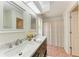 Bathroom with double vanity, marble countertop, and shower with patterned curtain at 7810 34Th E Ct, Sarasota, FL 34243