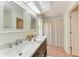 Bathroom with double vanity, marble countertop, and shower with patterned curtain at 7810 34Th E Ct, Sarasota, FL 34243