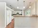 Bright kitchen features white cabinets, breakfast bar with pendant lighting, and tile backsplash at 7810 34Th E Ct, Sarasota, FL 34243