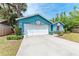 Exterior view of a quaint blue house with a well-maintained lawn and driveway at 7810 34Th E Ct, Sarasota, FL 34243