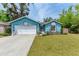 Charming blue home with a well-manicured lawn and a white two-car garage at 7810 34Th E Ct, Sarasota, FL 34243