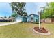 Exterior elevation of a blue one-story house with manicured front yard at 7810 34Th E Ct, Sarasota, FL 34243
